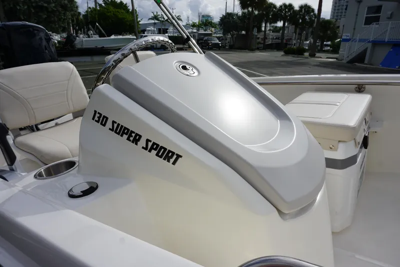 Slide: The Image of 2026 Boston Whaler 130 Super Sport boat interior with steering wheel and seating. - 11