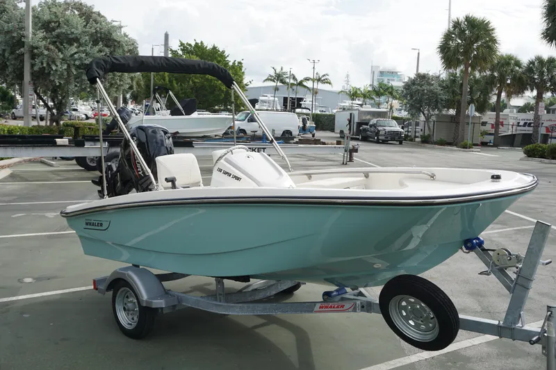 Slide: The Image of 2026 Boston Whaler 130 Super Sport boat on trailer in parking lot. - 5