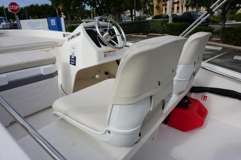 Slide: The Image of 2026 Boston Whaler 130 Super Sport interior with steering wheel and seating. - 8