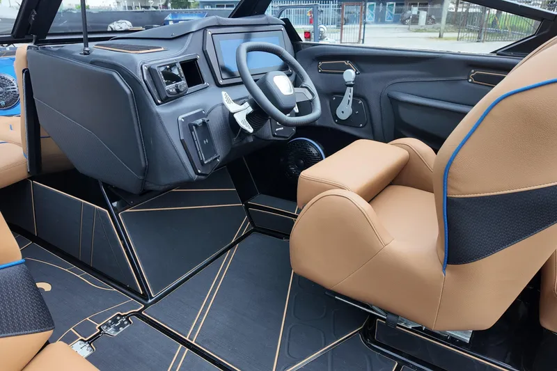 Slide: The Image of 2025 Centurion Fe23 boat interior with tan leather seats and modern dashboard. - 11