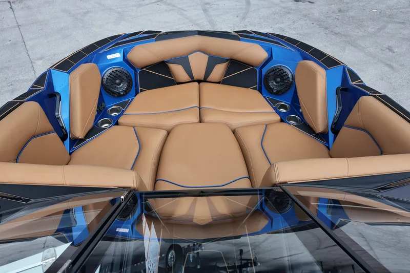 Slide: The Image of 2025 Centurion Fe23 boat interior with tan and blue seating, speakers, and cup holders. - 15