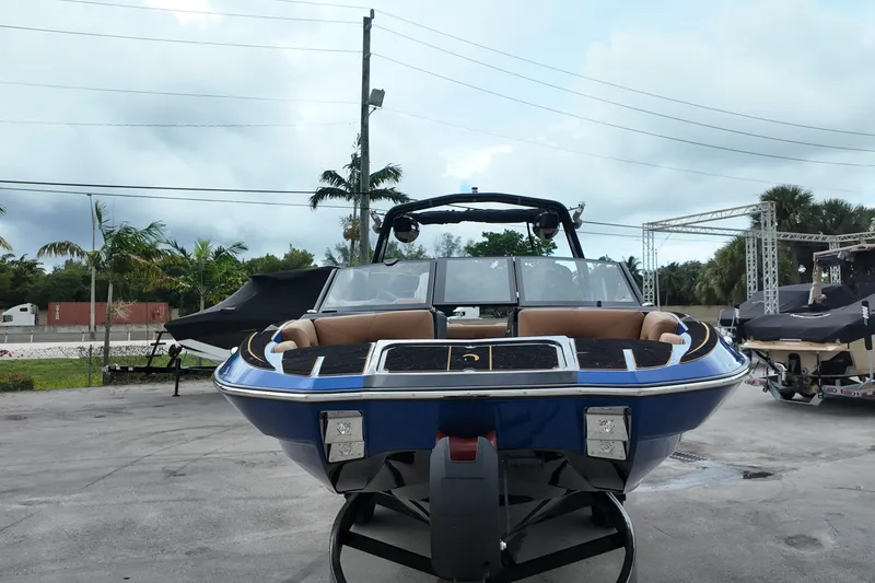 Slide: The Image of 2025 Centurion Fe23 boat with sleek design, parked outdoors on a cloudy day. - 2