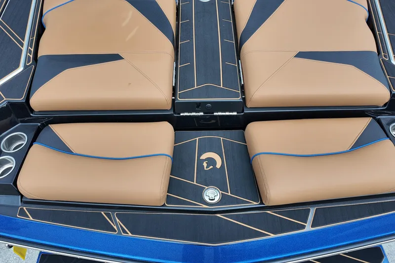 Slide: The Image of 2025 Centurion Fe23 boat interior with tan and black seating, blue accents, and cup holders. - 8