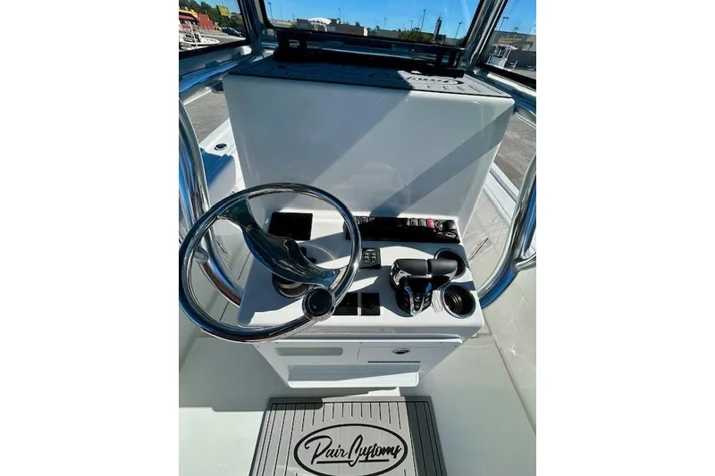 Slide: The Image of 2026 Pair Customs 24 Center Console DV Offshore boat helm with steering wheel and controls. - 17