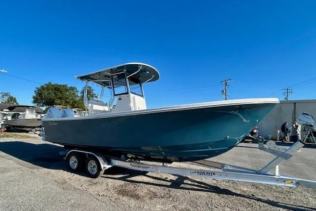 Slide: The Image of 2026 Pair Customs 24 Center Console DV Offshore boat on trailer, blue hull, sunny day. - 4