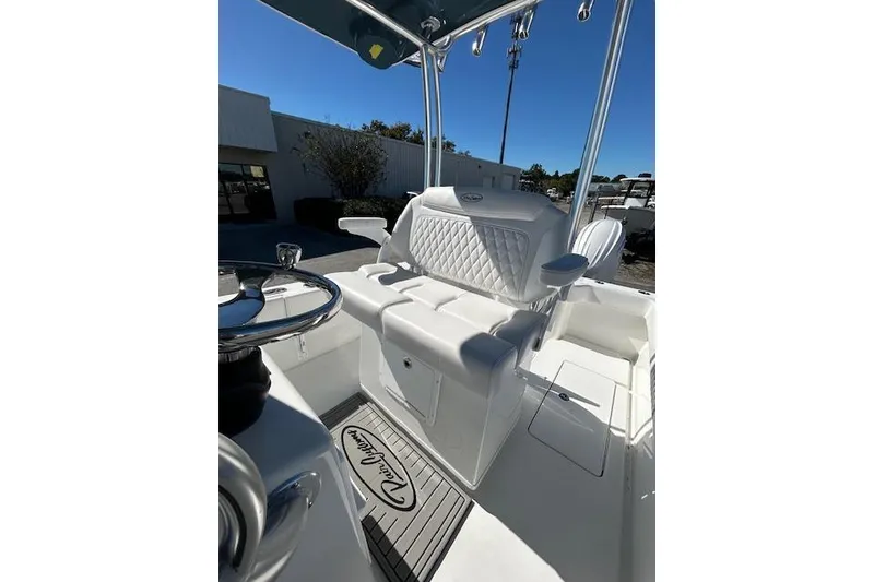 Slide: The Image of 2026 Pair Customs 24 Center Console DV Offshore boat interior with white seating and steering wheel. - 7