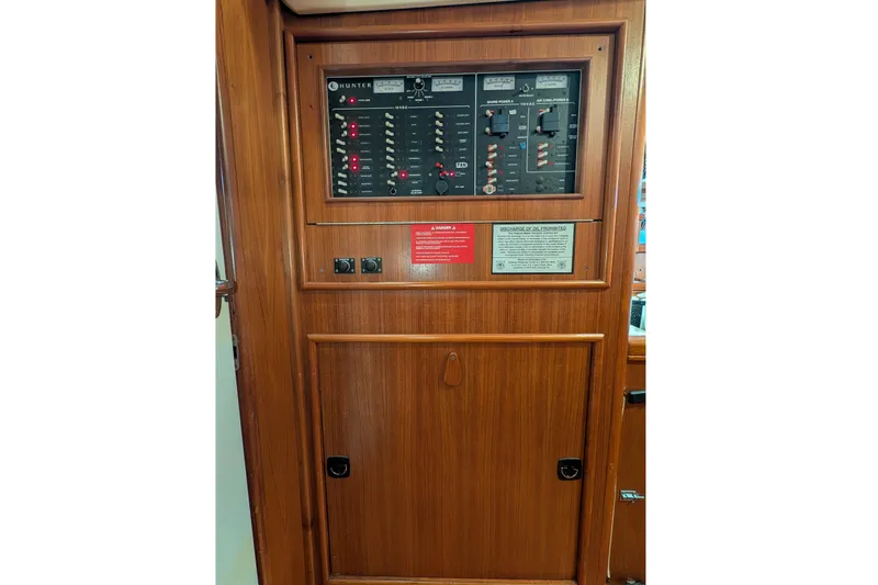 Slide: The Image of Electrical panel on a 2002 Hunter 450 Passage sailboat, featuring wooden cabinetry. - 40