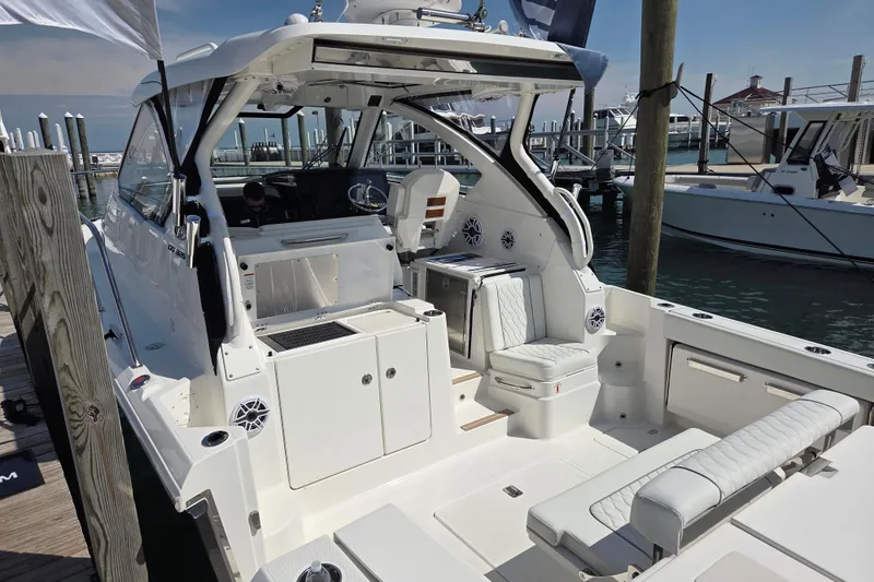 Slide: The Image of 2026 Pursuit OS 325 Offshore boat docked, featuring spacious seating and modern amenities. - 26