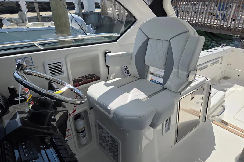 Slide: The Image of Helm of 2026 Pursuit OS 325 Offshore boat with luxurious seating and modern controls. - 28