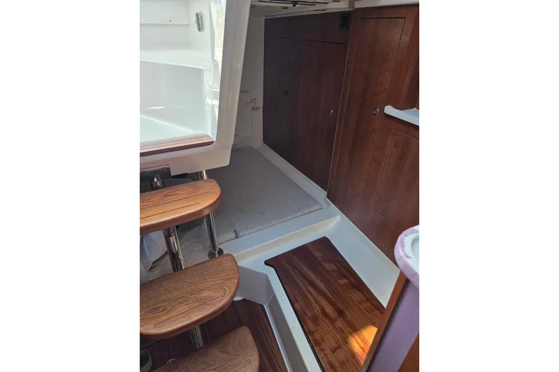 Slide: The Image of Interior of 2026 Pursuit OS 325 Offshore boat with wooden steps and cabinetry. - 31