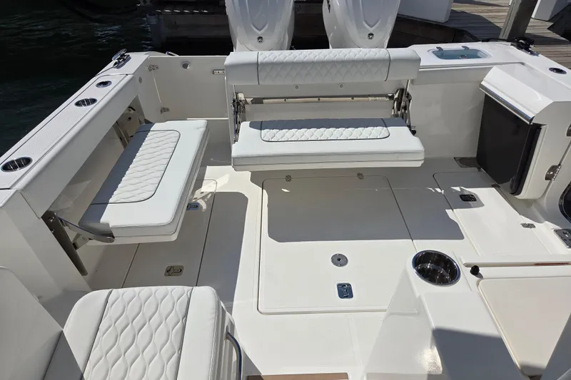 Slide: The Image of 2026 Pursuit OS 325 Offshore boat interior with white cushioned seating and sleek design. - 33
