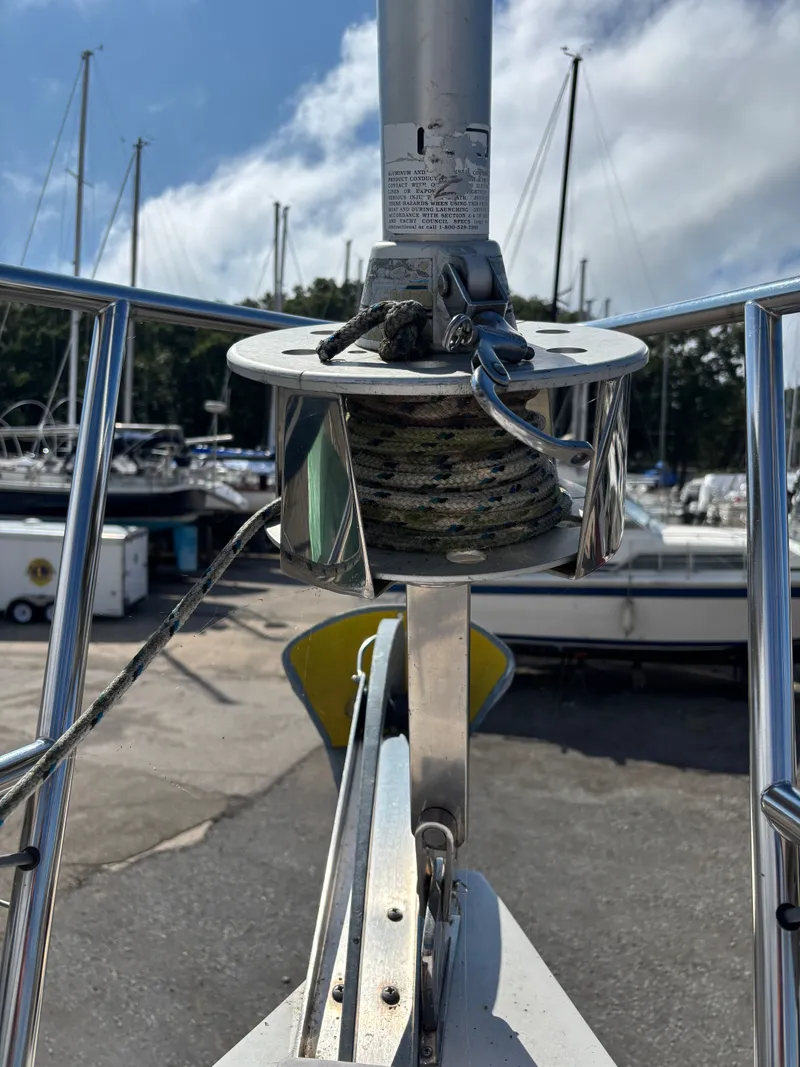 Slide: The Image of Catalina 380 sailboat bow with furler, docked in a marina, clear sky background. - 14