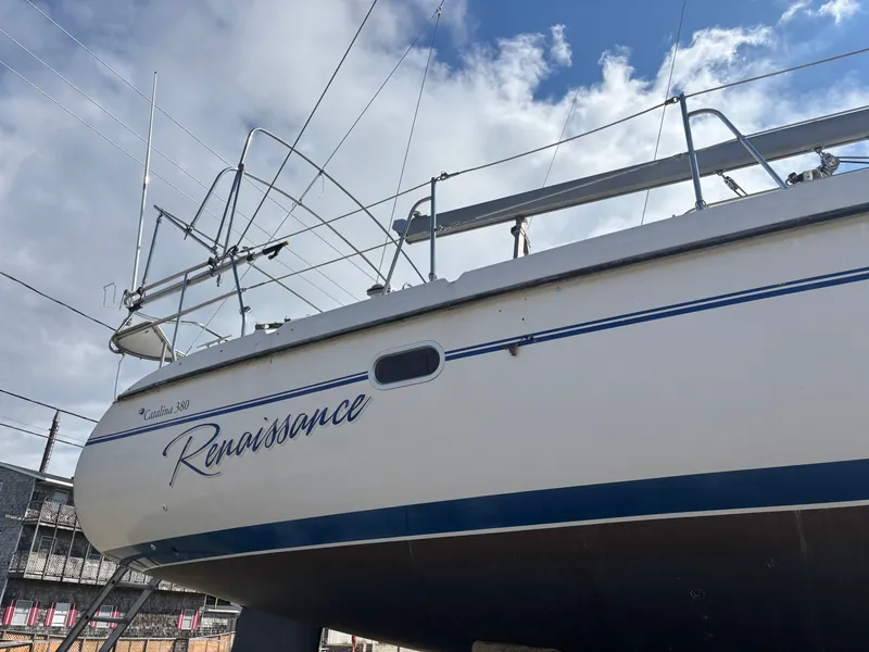 Slide: The Image of Catalina 380 sailboat named "Renaissance" from 2000, docked under a cloudy sky. - 2