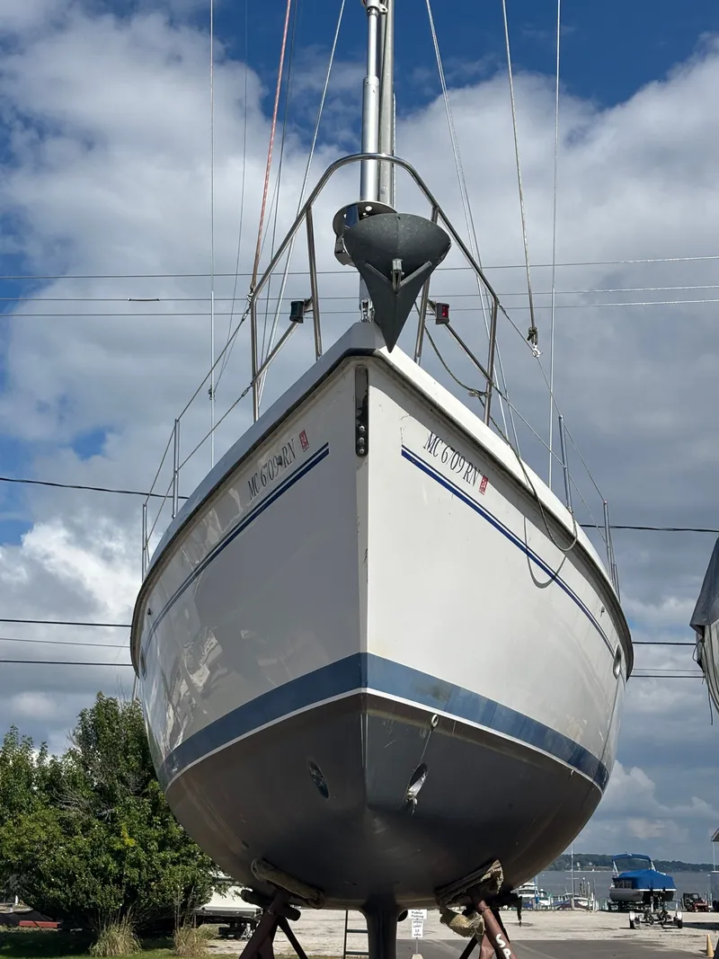 Slide: The Image of Catalina 380 sailboat from 2000 on land, under a partly cloudy sky. - 5