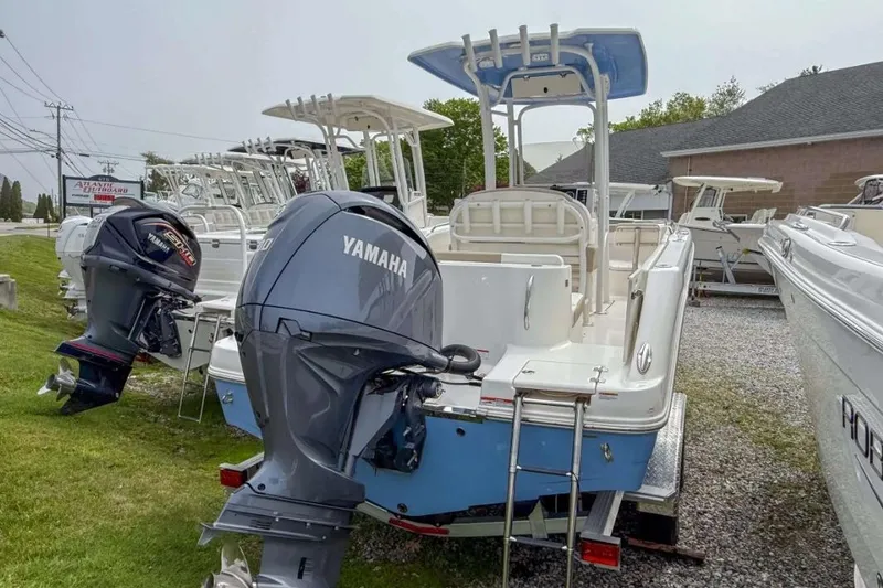 Slide: The Image of 2024 Robalo R222 Explorer boat with Yamaha outboard motor, displayed outdoors. - 2