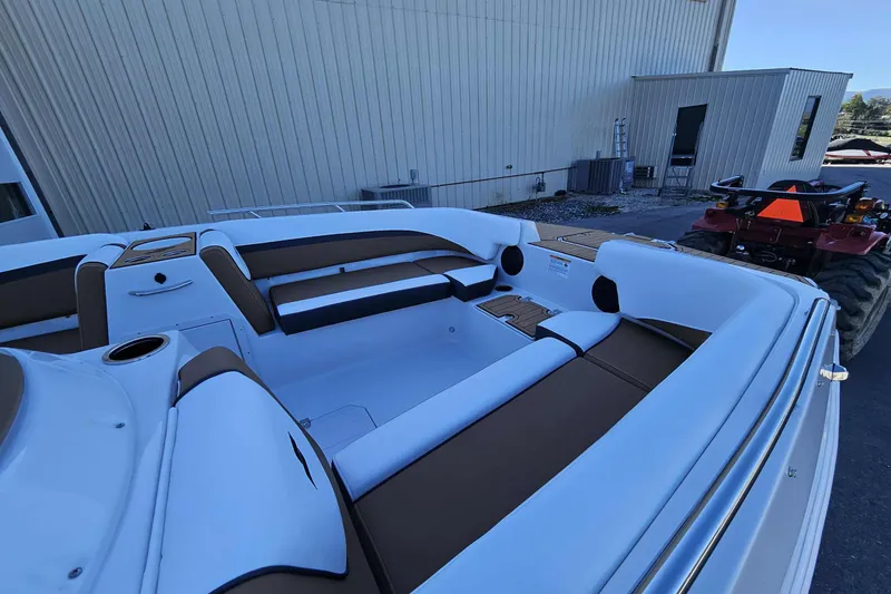 Slide: The Image of 2026 Starcraft SVX 191 OB boat interior with brown and white seating, parked outdoors. - 4