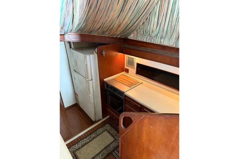 Slide: The Image of 1984 Bertram 46 Convertible yacht kitchen with wood cabinetry and appliances. - 10