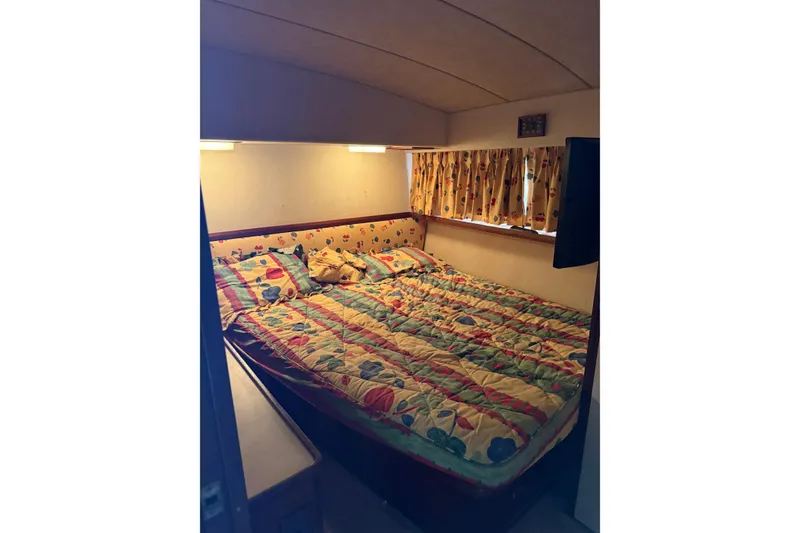 Slide: The Image of Cozy bedroom in 1984 Bertram 46 Convertible yacht with colorful bedding and curtains. - 11