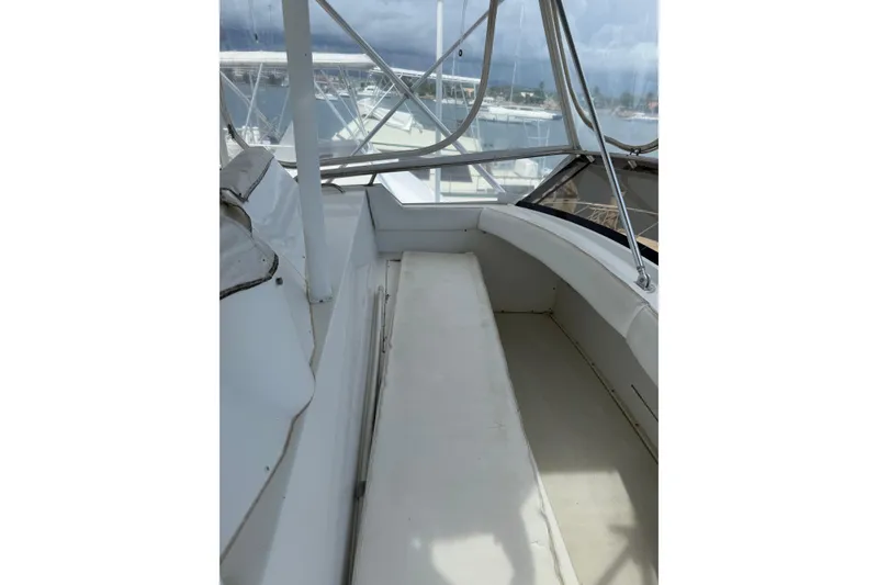 Slide: The Image of 1984 Bertram 46 Convertible boat interior with seating and windows, showcasing nautical design. - 6