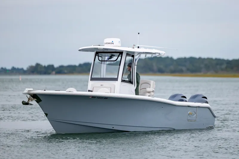 The Image of 2021 Sea Hunt Gamefish 25 boat on calm water, featuring dual engines and sleek design. - 1