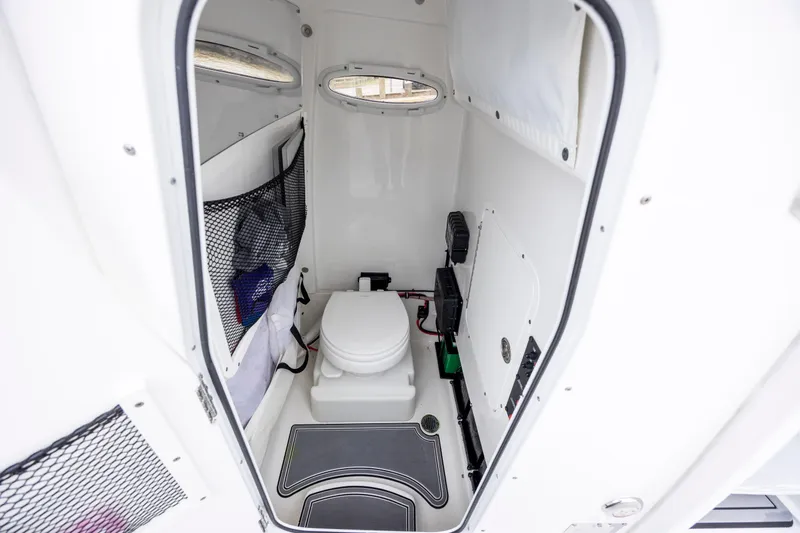 Slide: The Image of 2021 Sea Hunt Gamefish 25 boat interior with compact marine toilet and storage. - 14
