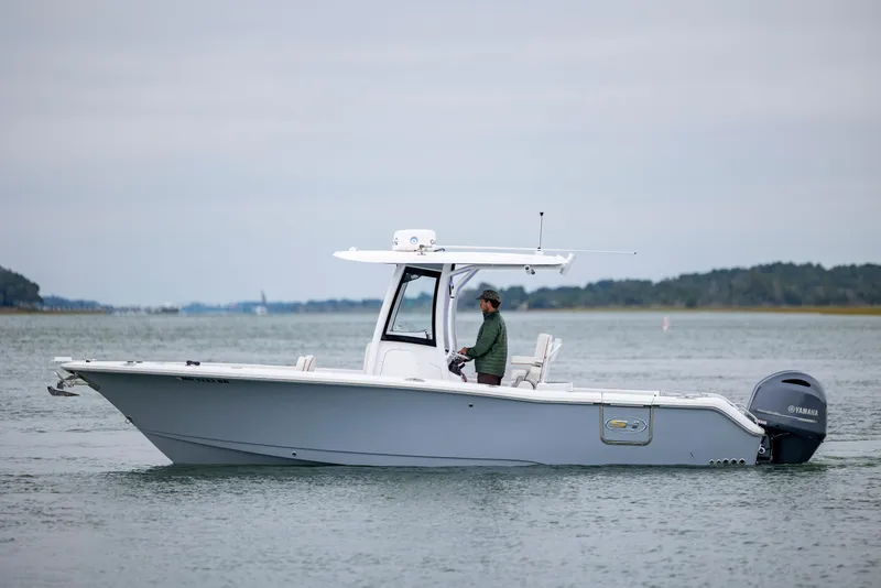 Slide: The Image of 2021 Sea Hunt Gamefish 25 boat on water, side view with Yamaha engine. - 2