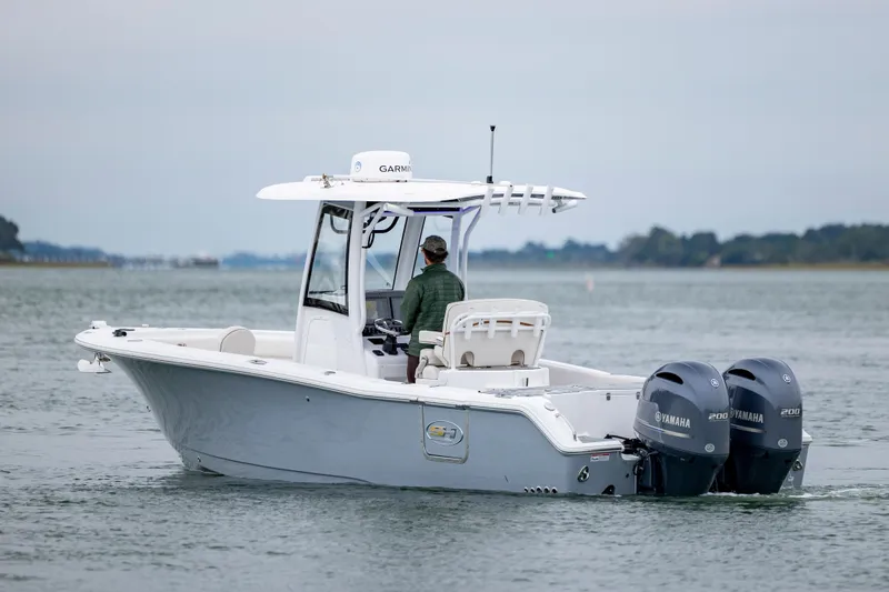 Slide: The Image of 2021 Sea Hunt Gamefish 25 boat with dual Yamaha engines on calm water. - 3
