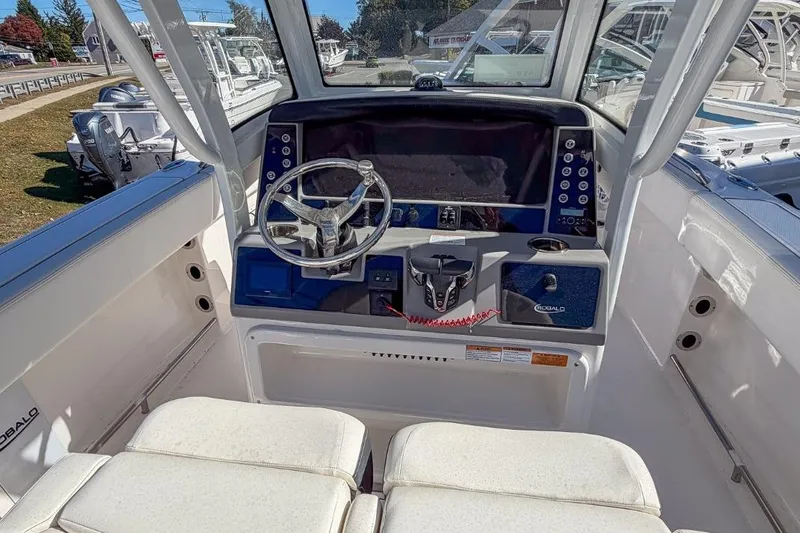 Slide: The Image of 2024 Robalo R250 Center Console boat helm with modern controls and steering wheel. - 11