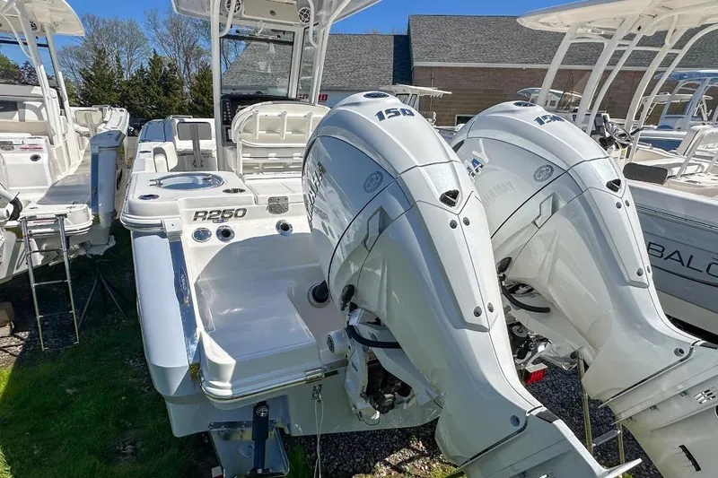 Slide: The Image of 2024 Robalo R250 Center Console boat with dual outboard engines displayed outdoors. - 14