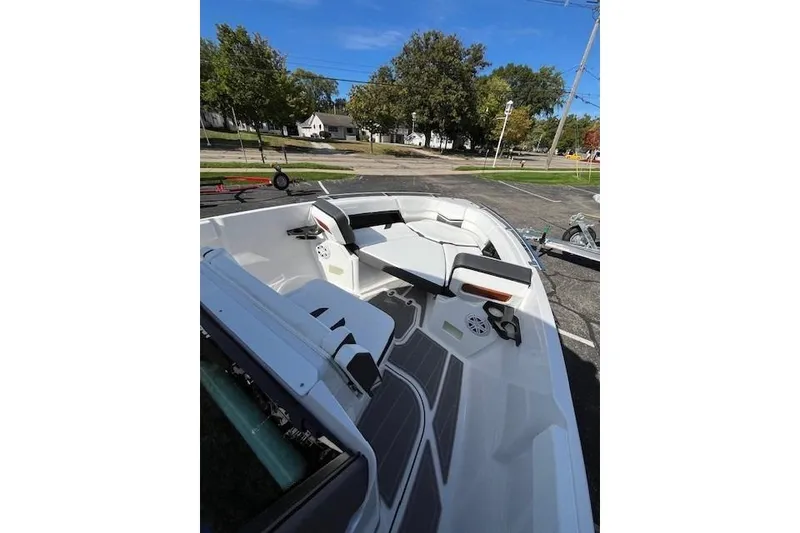 Slide: The Image of 2026 Monterey Elite 27 SD boat interior with seating and cup holders, parked outdoors. - 19