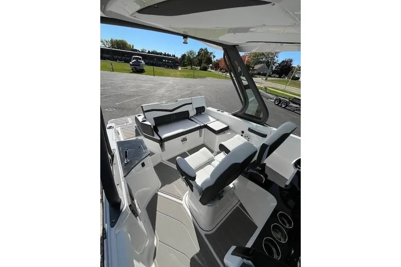 Slide: The Image of 2026 Monterey Elite 27 SD boat interior with seating and dashboard, parked outdoors. - 20
