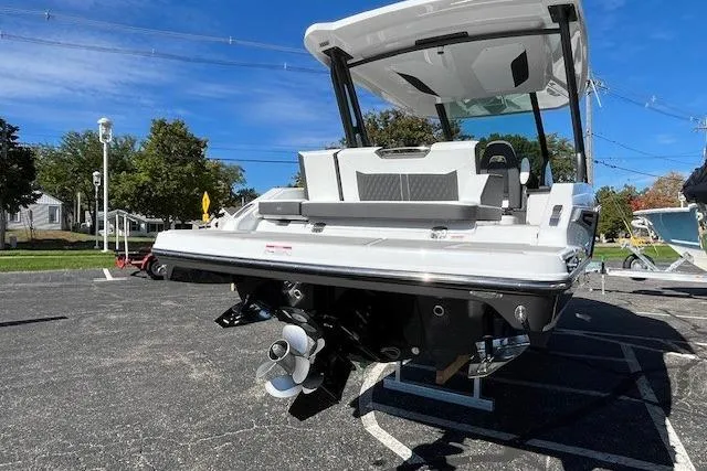 Slide: The Image of 2026 Monterey Elite 27 SD boat, rear view, parked outdoors on a sunny day. - 23