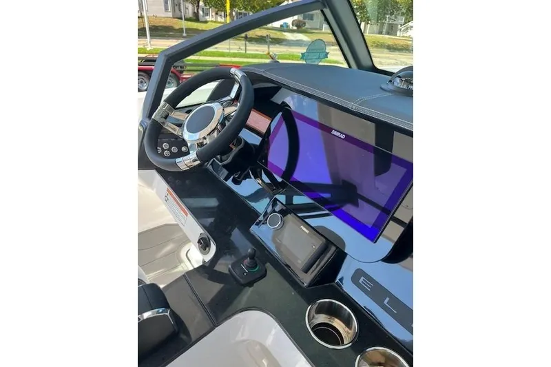 Slide: The Image of Cockpit of 2026 Monterey Elite 27 SD boat with modern steering and navigation display. - 9
