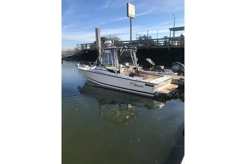 Slide: The Image of 1994 Albemarle Sportfish boat docked in calm waters under a clear blue sky. - 16