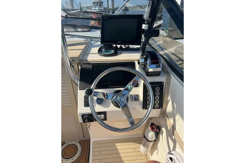 Slide: The Image of 1994 Albemarle Sportfish helm with steering wheel, controls, and navigation equipment. - 8