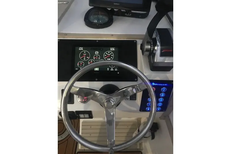 Slide: The Image of 1994 Albemarle Sportfish helm with steering wheel, gauges, and controls. - 13