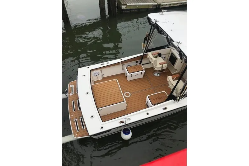 Slide: The Image of 1994 Albemarle Sportfish boat with wooden deck, docked in calm waters. - 15