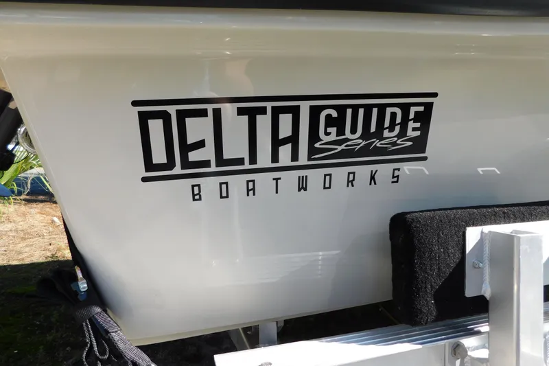 Slide: The Image of 2026 Delta Boatworks Delta D-18 Tiller with outboard motor, parked outdoors. - 24
