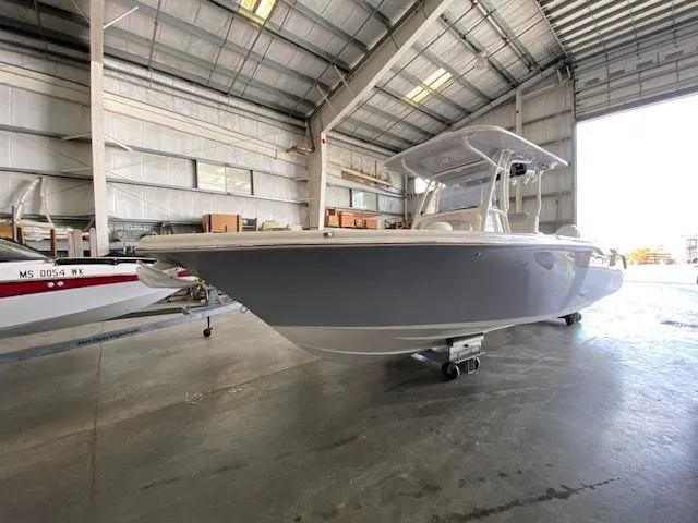 Slide: The Image of 2026 Key West 263 FS boat with Yamaha engines, parked outdoors near trees and a building. - 2