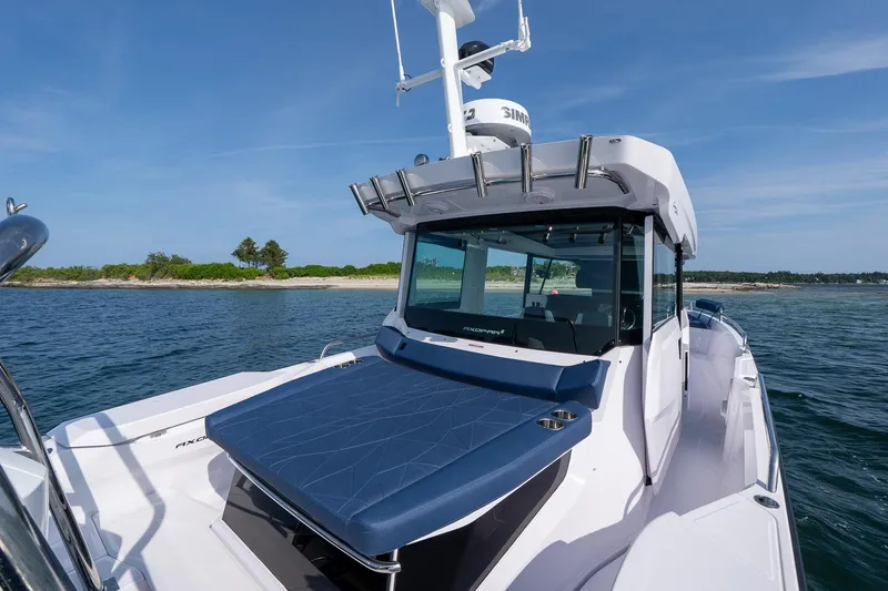 Slide: The Image of 2026 Axopar 29 Cross Cabin boat on water, featuring a sleek design and powerful Mercury engine. - 12