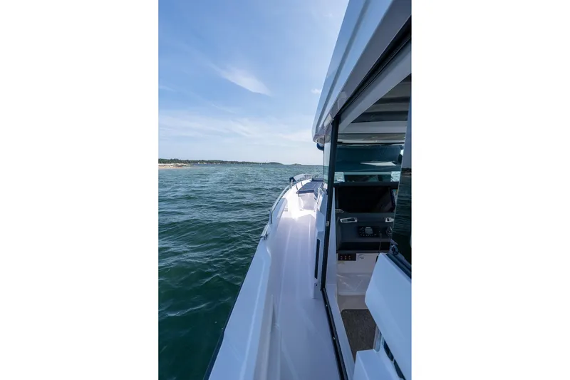 Slide: The Image of 2026 Axopar 29 Cross Cabin boat with sleek seating on open water. - 17