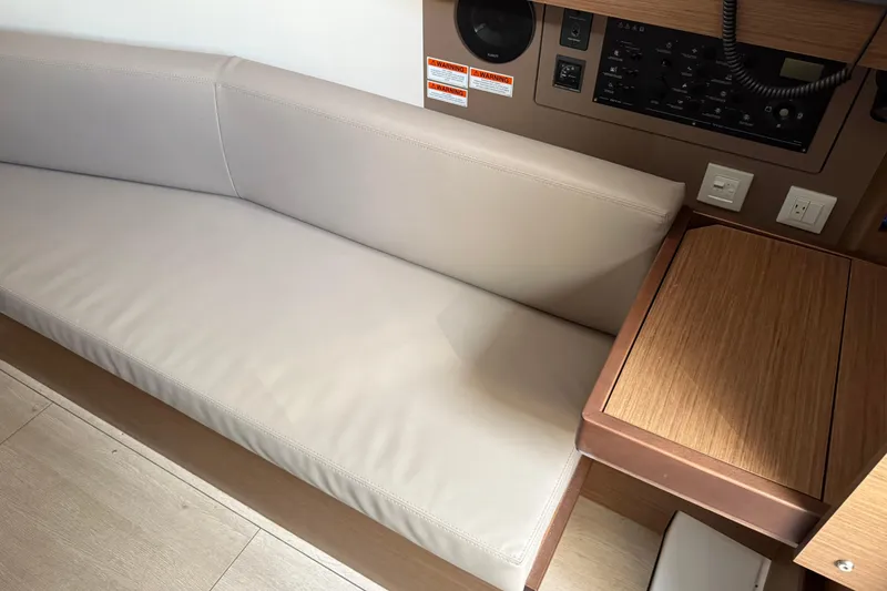 Slide: The Image of Interior of 2021 Beneteau Oceanis 35.1 yacht with beige seating and control panel. - 17