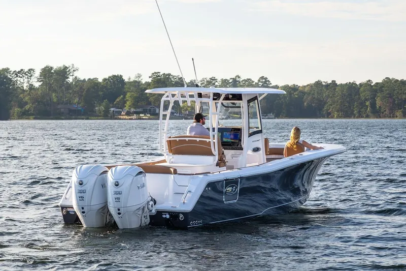 Slide: The Image of 2026 Sea Hunt Ultra 285 SE boat with cushioned seating on a serene lake. - 10