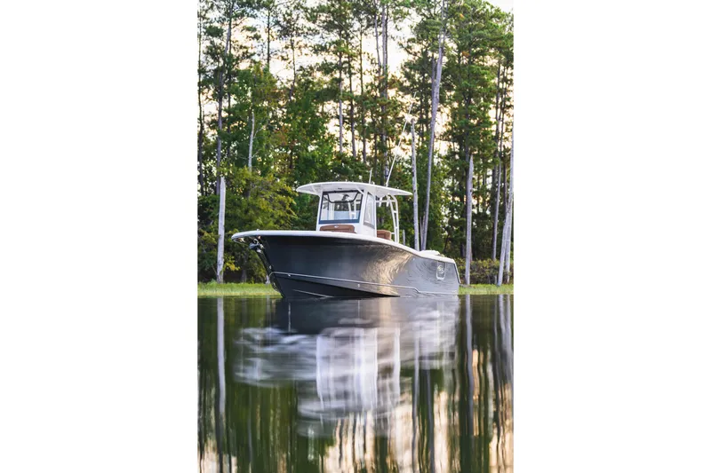 Slide: The Image of 2026 Sea Hunt Ultra 285 SE boat on calm water with forest backdrop. - 15