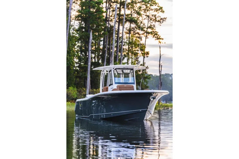Slide: The Image of 2026 Sea Hunt Ultra 285 SE boat on calm water, surrounded by trees. - 16