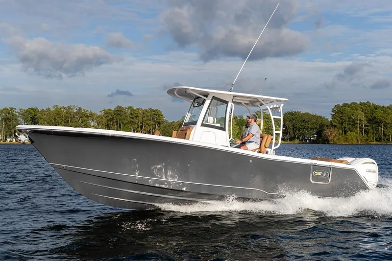 Slide: The Image of 2026 Sea Hunt Ultra 285 SE boat on calm water at sunset, featuring Yamaha engines. - 2