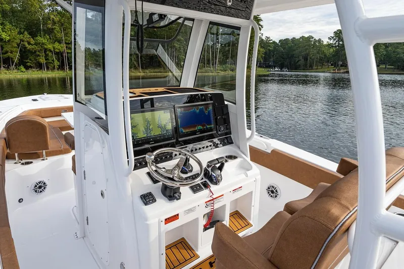 Slide: The Image of 2026 Sea Hunt Ultra 285 SE boat on calm water, surrounded by trees. - 9