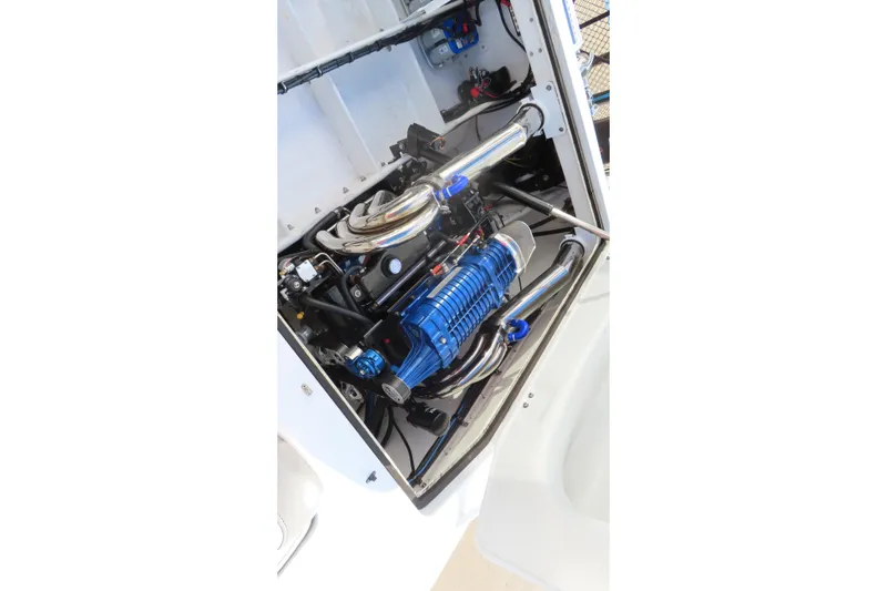 Slide: The Image of Engine compartment of a 1997 Skater 36 boat, featuring a blue engine and chrome components. - 14