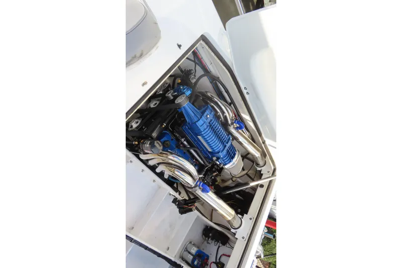 Slide: The Image of Engine compartment of a 1997 Skater 36 boat, featuring a blue engine and chrome exhaust pipes. - 15