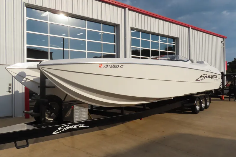 Slide: The Image of 1997 Skater 36 powerboat on trailer outside a garage, showcasing sleek design and white exterior. - 3